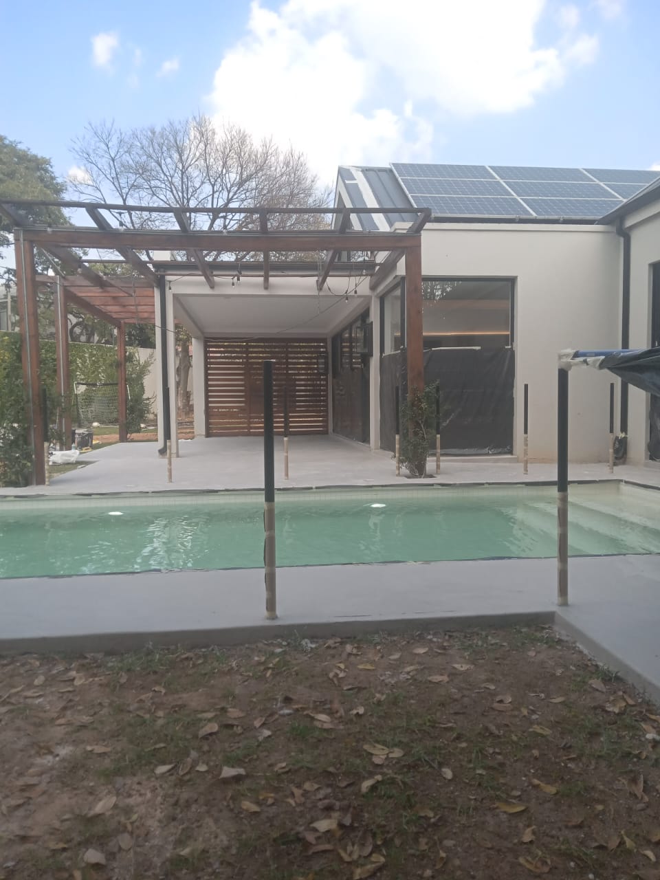 Site photo showing a smooth-troweled pool deck laid before the surrounding area is completed