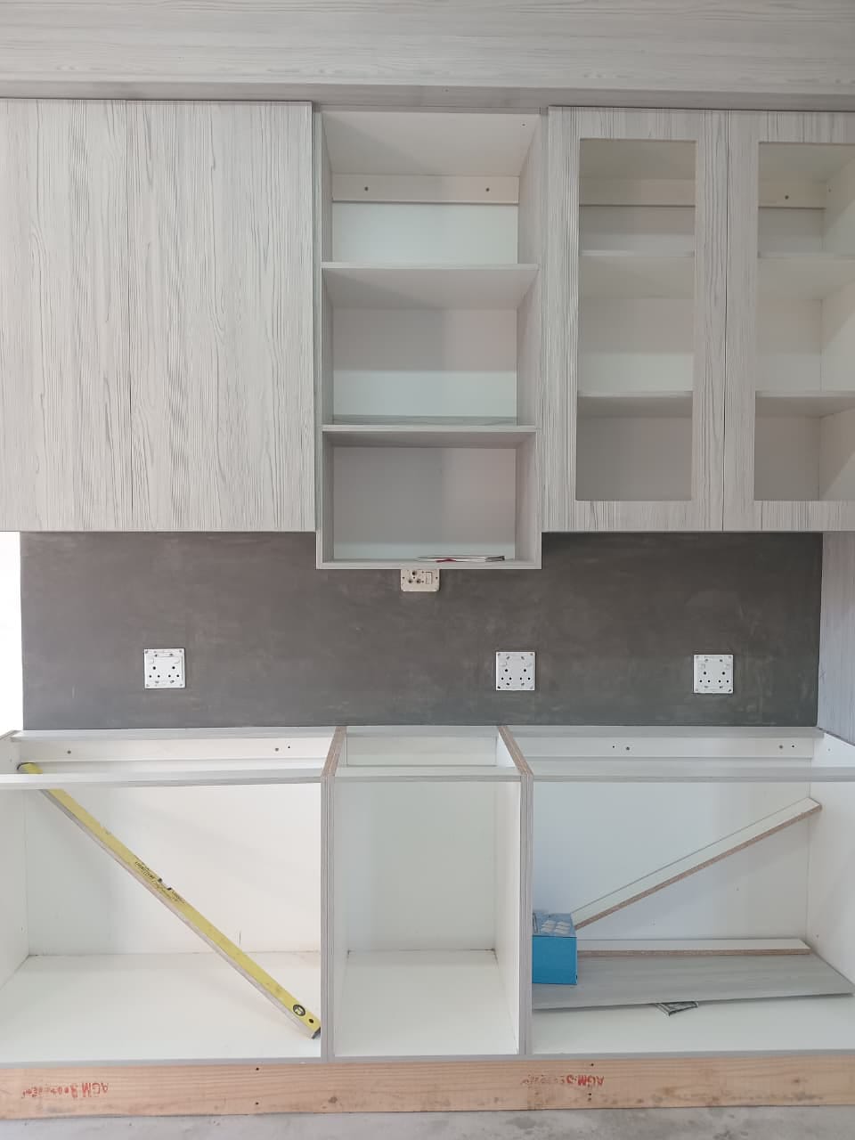 Site photo showing a dark wall and splashback finish during a kitchen fit-out