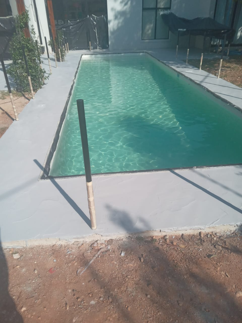 Site photo showing a smooth-troweled pool surround laid before the surrounding area is completed