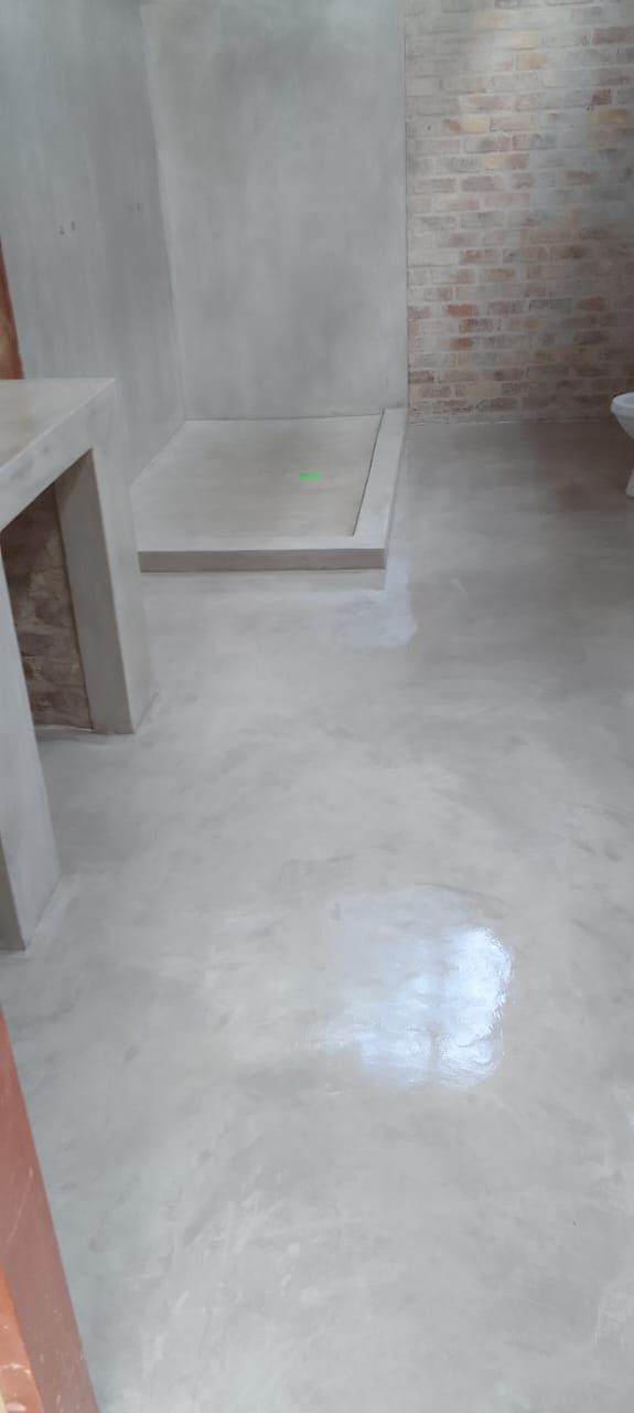 Site photo showing a bathroom with fresh wall and floor coatings, still being fitted out