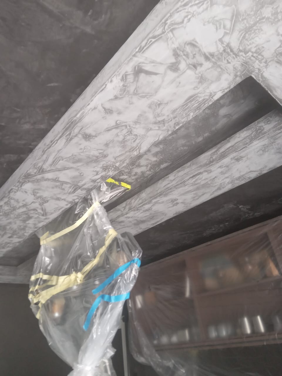 Site photo showing a textured plaster ceiling feature while the room is still being finished